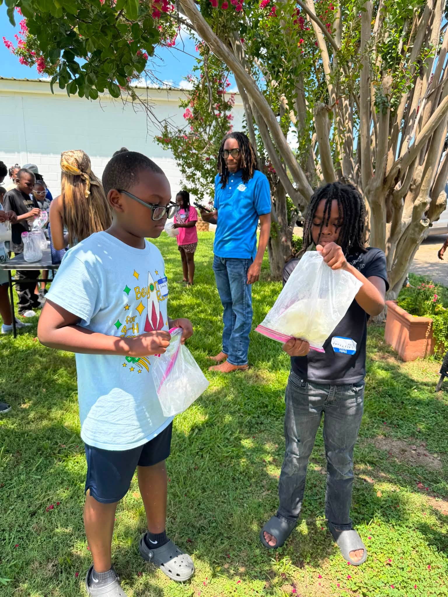 Two kids holding gallon size freezer bags.